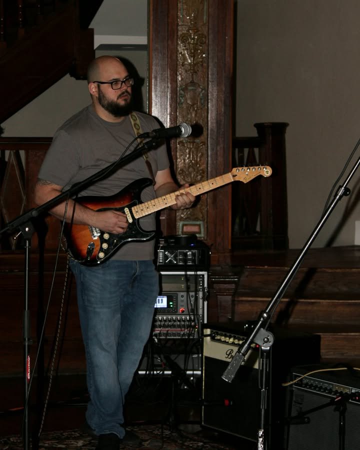 Jared writes in the gaps. Between run-throughs at rehearsal, while everyone else is resetting, he's quietly working out a new lick. These are the rhythms that make the foundation…